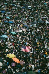 Photo of a crowd and American flag by Joseph Chan on Unsplash