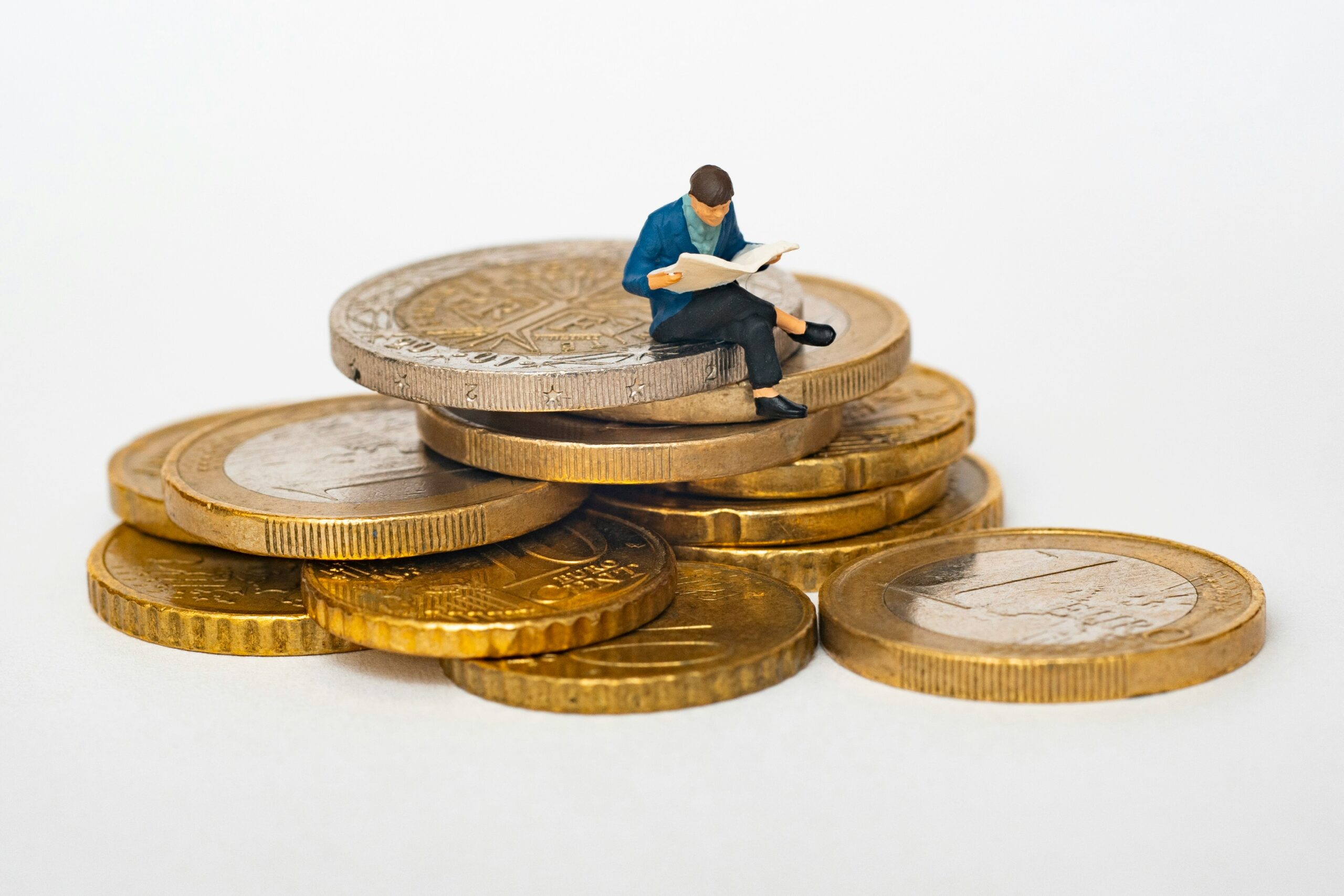 Small figure sitting on huge coins