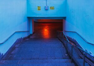 A stairway leading to a passageway bathed in red light