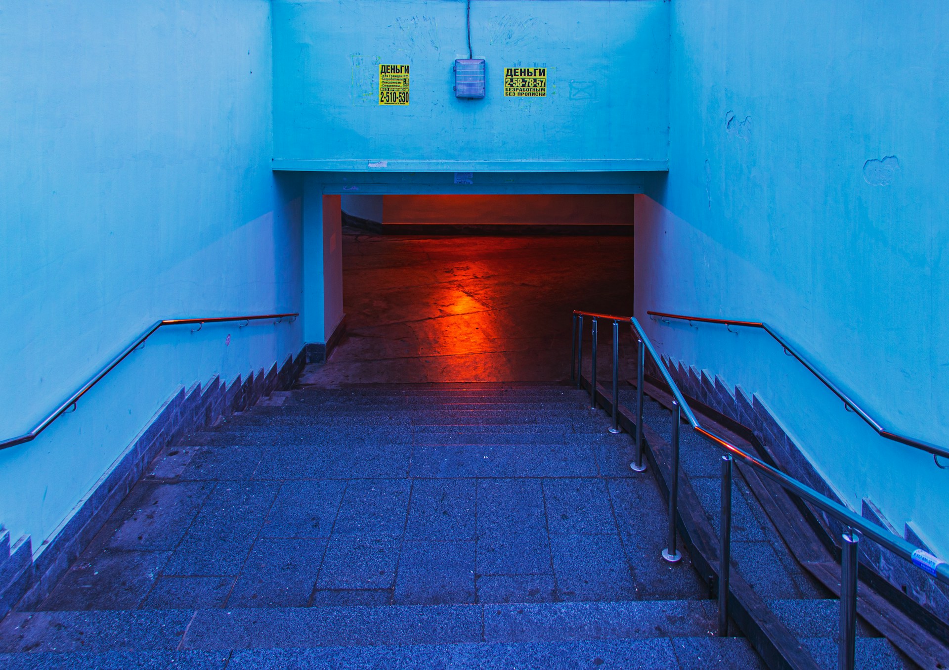 A stairway leading to a passageway bathed in red light
