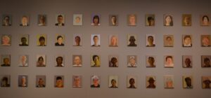 A wall of small painted portraits