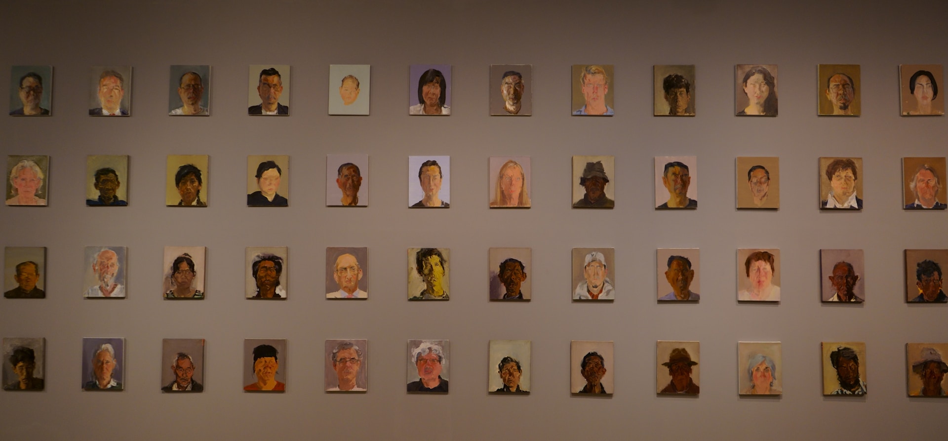 A wall of small painted portraits