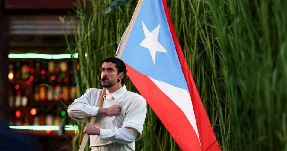 Bad Bunny holding a light blue Puerto Rican flag
